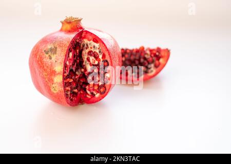 Weißer Hintergrund, schmutziges hormonfreies rotes Granatapfel. Isolierter, alter Stil, natürliche geschnittene ​​pomegranate Stockfoto