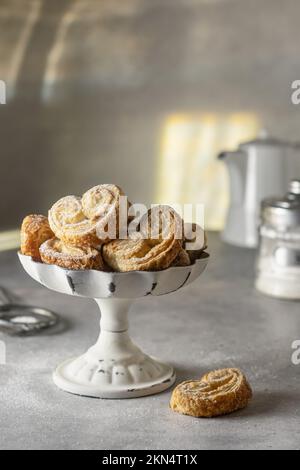Blätterteig Plätzchen palmier oder Elefantenohren, knuspriges Gebäck Herz in weißer Form, Frühstückskonzept Stockfoto