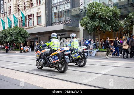 Zwei australische Polizeibeamte auf Polizeimotorrädern im zentralen Geschäftsviertel von Melbourne, beobachten einen protestmarsch in der Stadt, Victoria, Australien Stockfoto