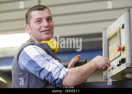 Männliche Weingut Arbeiter mit der Abfüllung von Maschinen im Werk Stockfoto