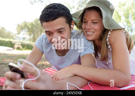 Ein schönes Paar, das Musik auf den Kopfhörern spielte Stockfoto