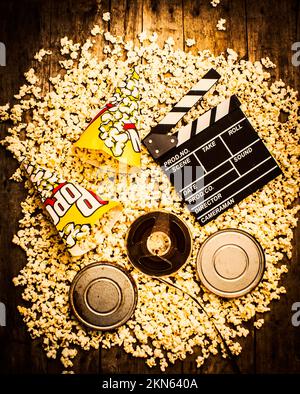 Mischung aus altmodischen Medienobjekten mit antiken Filmproduktions-Ikonen, die auf Popcorn-Hintergrund verstreut sind. Kino der Unterhaltung Stockfoto