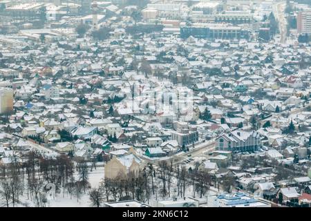 Panoramablick über den Winter auf das Dorf mit Häusern, Scheunen und Schotterstraße mit Schnee Stockfoto
