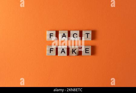 Falsche Wortfolge in Holzbuchstaben. Motivation und Slogan. Orangefarbener Hintergrund. Stockfoto