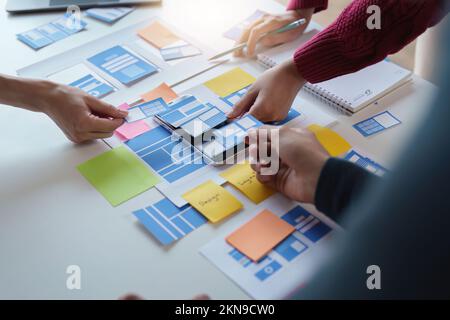 Gruppe von UX-UI oder Designern, die an der Erstellung von Inhalten für mobile Anwendungen arbeiten. Konzept der Agentur für kreative digitale Entwicklung Stockfoto