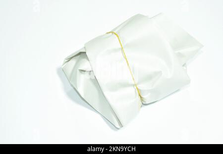 Fertigmahlzeit in Papierverpackung mit Gummiband auf weißem Hintergrund Stockfoto