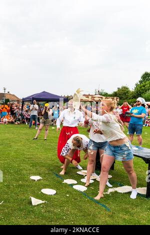 Ein Team aus vier Ukrainern, die während der World Custard Pie Championships in Maidstone, England, im Freien Custard Pie Pies von einem Tisch werfen Stockfoto