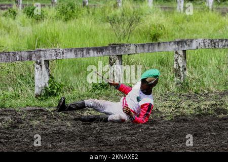 Bantul, Indonesien. 27.. November 2022. Ein Jockey stürzte während des Pferderennsports bei der King Hamengku Buwono X Cup Horse Racionship 2022 auf der Sultan Agung Horse Race Track, Bantul, Special Region of Yogyakarta. An der Meisterschaft, die jedes Jahr regelmäßig stattfindet, nahmen 157 Pferde aus mehreren Regionen Indonesiens Teil. Kredit: SOPA Images Limited/Alamy Live News Stockfoto