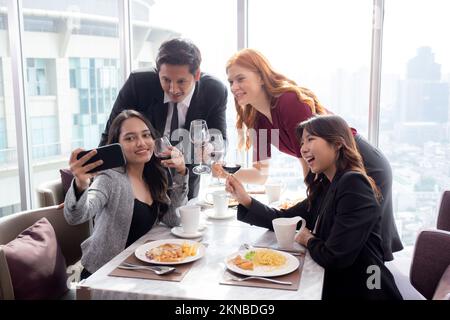 Glückliches Team junge Geschäftsleute feiern Erfolg Selfie und machen ein Foto mit Freunden im Restaurant, Freundschaft und sozialem Kollegen Stockfoto
