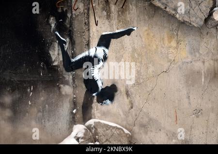 BORODIANKA, UKRAINE - 22. NOVEMBER 2022 - das Wandgemälde des englischen Straßenkünstlers Banksy zeigt einen Turner, der an der Wand eines Wohnungsbaus zu sehen ist Stockfoto
