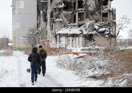 BORODIANKA, UKRAINE - 22. NOVEMBER 2022 - Menschen gehen an den Ruinen eines Wohnungsgebäudes vorbei, das von russischen Truppen zerstört wurde, wo die englische Straße A ihren Sitz hatte Stockfoto