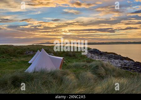 Zelte bei Sonnenuntergang mit dramatischem Wolkenhimmel am Clifton Beach in der Grafschaft Galway, westlicher Teil der Republik Irland Stockfoto