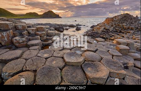 atlantikküste mit vulkanischen sechseckigen Basaltsäulen am Giant's Causeway bei Sonnenuntergang in Nordirland Stockfoto