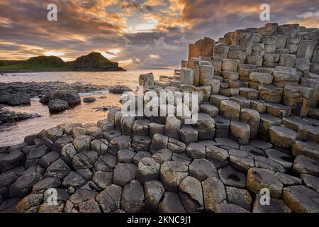 atlantikküste mit vulkanischen sechseckigen Basaltsäulen am Giant's Causeway bei Sonnenuntergang in Nordirland Stockfoto