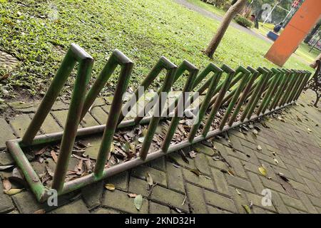 Fahrradparkplatz im Park auf einem Fußweg aus Pflastersteinen Stockfoto