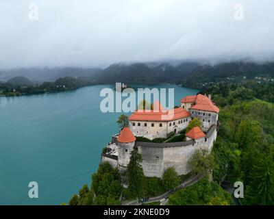 Bled Schloss Slowenien Drohne aus der Vogelperspektive neblige Wolken im Hintergrund Stockfoto