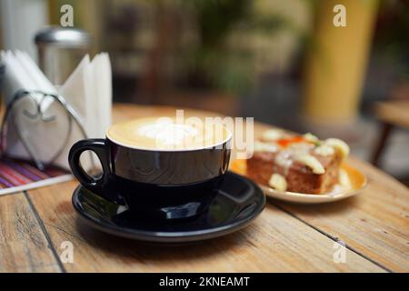 Cappuccino-Kaffee und Karottenkuchen auf einem Tisch in einem Café in Sucre, Bolivien. Stockfoto