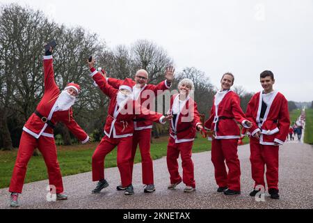 Windsor, Großbritannien. 27. November 2022. Lustige Läufer, die als Weihnachtsmann verkleidet sind, halten auf dem langen Spaziergang im Windsor Great Park während des Windsor Santa Dash im Jahr 2022 an und posieren für ein Foto, um dem Kinderhospiz Alexander Devine zu helfen. Die Veranstaltung des Vorjahres brachte £30.000 Dollar für das örtliche Kinderhospiz ein, das seit seiner Gründung im Jahr 2007 Hunderten von Kindern mit lebensbedrohlichen und lebensbedrohlichen Erkrankungen und ihren Familien fachkundige Betreuung und Unterstützung gewährt hat. Kredit: Mark Kerrison/Alamy Live News Stockfoto