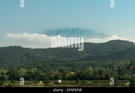 Ein hoher Berg hinter einem anderen Berg in der Wolke Stockfoto