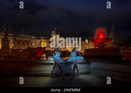 London, Großbritannien. 27.. November 2022. Weihnachtsballerinas: Die Zwillinge Abigail und Lauren Everard (L-R), die beide an der Theater-Tanzschule des London Studio Centre (LSC) in klassischem Ballett studiert haben, üben einige Moves mit speziellem LED-Tutus und Diaras bei der festlichen Weihnachtsbeleuchtung am Trafalgar Square. Kredit: Guy Corbishley/Alamy Live News Stockfoto