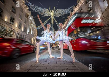 London, Großbritannien. 27.. November 2022. Weihnachtsballerinas: Die Zwillinge Abigail(R) und Lauren(L) Everard, beide Absolventen des klassischen Balletts der Theater-Tanzschule London Studio Centre (LSC), üben einige Bewegungen mit speziellem LED-Ballett-Tutus und Diaras unter der festlichen Stadtbeleuchtung. Kredit: Guy Corbishley/Alamy Live News Stockfoto