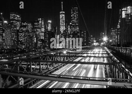 Eine Grauskala-Langzeitaufnahme der Lichtpfade auf der Straße von der Brooklyn Bridge Stockfoto