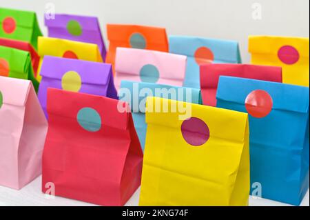 Set aus farbenfrohen gefalteten Papiertüten auf weißem Hintergrund. Einkaufstaschen aus Papier, Muster, leere rechteckige Geschenksets. Modell für Marke und Logo. Stockfoto