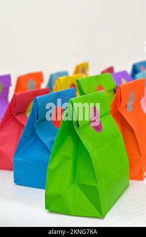 Set aus farbenfrohen gefalteten Papiertüten auf weißem Hintergrund. Einkaufstaschen aus Papier, Muster, leere rechteckige Geschenksets. Modell für Marke und Logo. Stockfoto