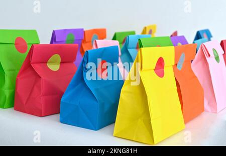 Set aus farbenfrohen gefalteten Papiertüten auf weißem Hintergrund. Einkaufstaschen aus Papier, Muster, leere rechteckige Geschenksets. Modell für Marke und Logo. Stockfoto