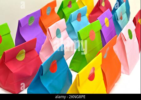 Set aus farbenfrohen gefalteten Papiertüten auf weißem Hintergrund. Einkaufstaschen aus Papier, Muster, leere rechteckige Geschenksets. Modell für Marke und Logo. Stockfoto