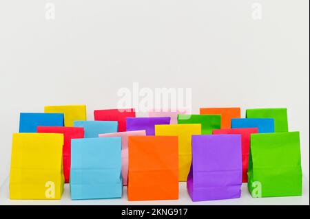 Set aus farbenfrohen gefalteten Papiertüten auf weißem Hintergrund. Einkaufstaschen aus Papier, Muster, leere rechteckige Geschenksets. Modell für Marke und Logo. Stockfoto