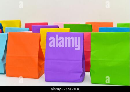 Set aus farbenfrohen gefalteten Papiertüten auf weißem Hintergrund. Einkaufstaschen aus Papier, Muster, leere rechteckige Geschenksets. Modell für Marke und Logo. Stockfoto