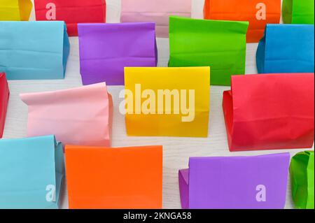 Set aus farbenfrohen gefalteten Papiertüten auf weißem Hintergrund. Einkaufstaschen aus Papier, Muster, leere rechteckige Geschenksets. Modell für Marke und Logo. Stockfoto