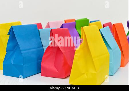Set aus farbenfrohen gefalteten Papiertüten auf weißem Hintergrund. Einkaufstaschen aus Papier, Muster, leere rechteckige Geschenksets. Modell für Marke und Logo. Stockfoto