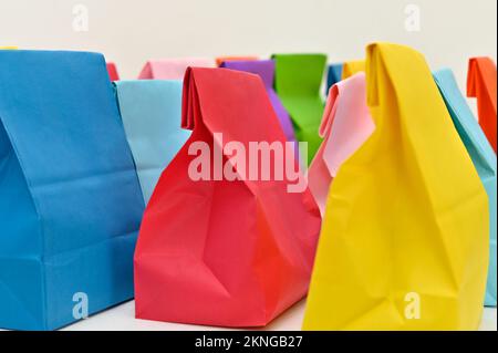 Set aus farbenfrohen gefalteten Papiertüten auf weißem Hintergrund. Einkaufstaschen aus Papier, Muster, leere rechteckige Geschenksets. Modell für Marke und Logo. Stockfoto