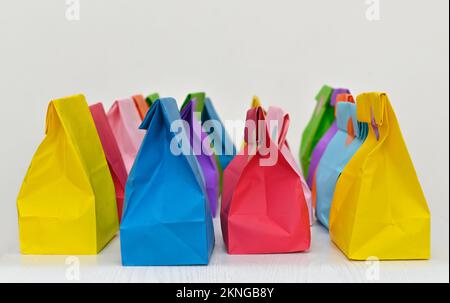 Set aus farbenfrohen gefalteten Papiertüten auf weißem Hintergrund. Einkaufstaschen aus Papier, Muster, leere rechteckige Geschenksets. Modell für Marke und Logo. Stockfoto
