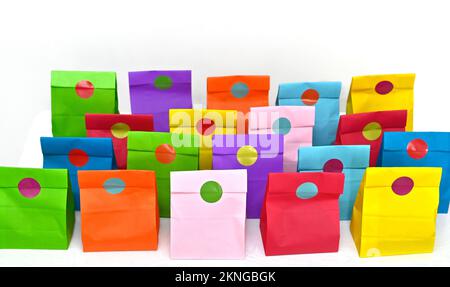 Set aus farbenfrohen gefalteten Papiertüten auf weißem Hintergrund. Einkaufstaschen aus Papier, Muster, leere rechteckige Geschenksets. Modell für Marke und Logo. Stockfoto