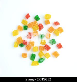 Haufen kandierter Fruchtstücke aus der Nähe isoliert auf weißem Hintergrund, süß getrocknete Ananas, Orangen und Papayas in Zuckersirup, als Füllung in con verwendet Stockfoto