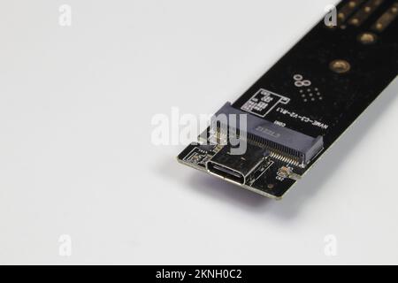 Nahaufnahme des M.2-zu-usb-Typ-C-Adapters für die Konvertierung der Schnittstelle von NVME PCIe m2 auf USB-Schnittstelle isoliert auf weißem Hintergrund Stockfoto