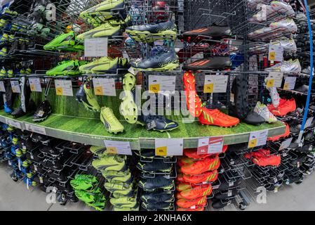 Cuneo, Italien - 22. November 2022: Farbenfrohe Fußballschuhe oder Fußballschuhe, die in Regalen im italienischen Dekathlon-Laden ausgestellt werden. Decathlon ist ein franzose Stockfoto