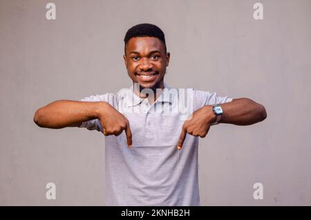 Ein afroamerikanischer Mann erstaunt, als er mit der Hand präsentierte und mit den Fingern zeigte Stockfoto