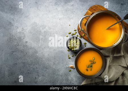 Kürbissuppe im Topf am Steintisch. Stockfoto