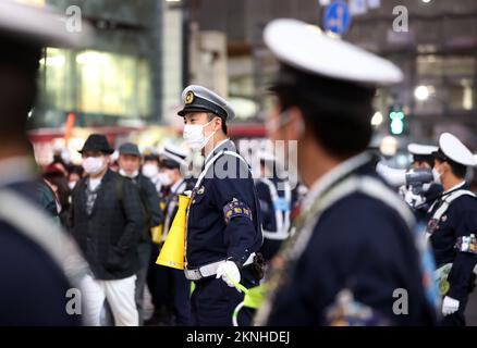 Tokio, Japan. 27.. November 2022. Polizeibeamte kontrollieren japanische Fußballfans, die sich am Freitag, den 27. November 2022, im Shibuya Modeviertel in Tokio versammeln. Japan wurde bei der FIFA-Weltmeisterschaft in Katar von Costa Rica 0-1 besiegt. Kredit: Yoshio Tsunoda/AFLO/Alamy Live News Stockfoto