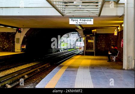 Athen Griechenland 1 5 2018 Frau, die am frühen Morgen an einer überdachten U-Bahnstation im Freien wartete, mit einem Zug, der sich nähert Stockfoto