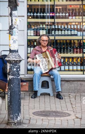 Juli 15 Tiflis Georgien - Mann auf Hocker vor dem Weinladen spielen Akkordeon in der Altstadt sitzen Stockfoto