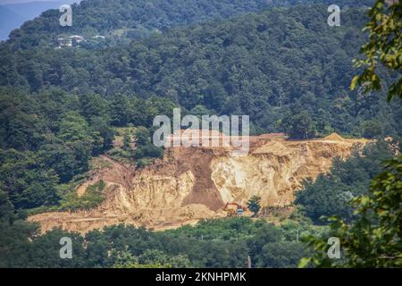 Maschinen und Erdrutsche auf einem Manganstreifen oder einem Tagebau im Bezirk Sachkhere in Georgien, der eines der reichsten Vorkommen der Welt hat Stockfoto