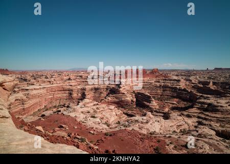 Blick vom Maze Overlook im Maze District des Canyonlands National Park in Utah. Ein paar Wolken sind am Horizont zu sehen, in einem ansonsten klaren Himmel Stockfoto