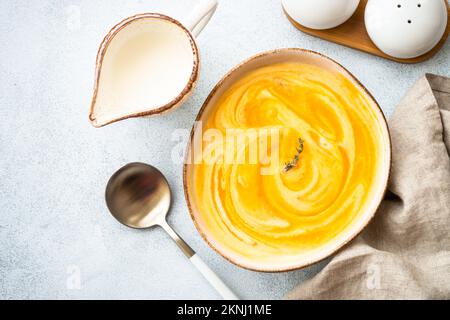 Kürbissuppe im Topf am Steintisch. Stockfoto