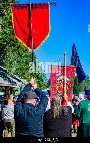 Bei der Parade der Clan-Tartane beim alljährlichen Celtic Music Festival und den Scottish Highland Games in Gulfport, Mississippi, tragen die Menschen Tartane mit sich. Stockfoto