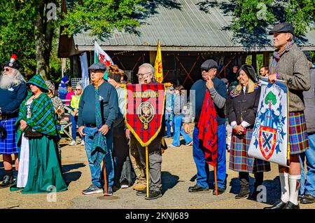 Bei der Parade von Clan-Tartanen bei den Scottish Highland Games in Gulfport, Mississippi, tragen die Menschen Tartanbanner mit sich. Stockfoto